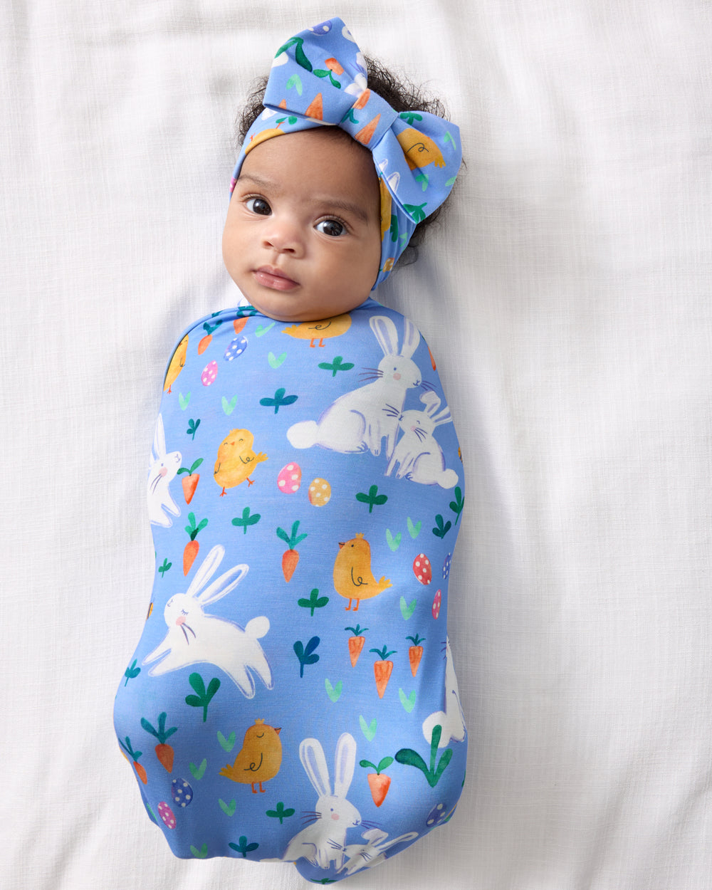 Aerial view of baby in the Bunny Patch Swaddle & Luxe Bow Headband Set