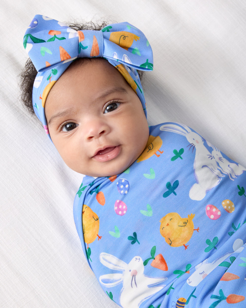 Close up of baby wearing the Bunny Patch Swaddle & Luxe Bow Headband Set