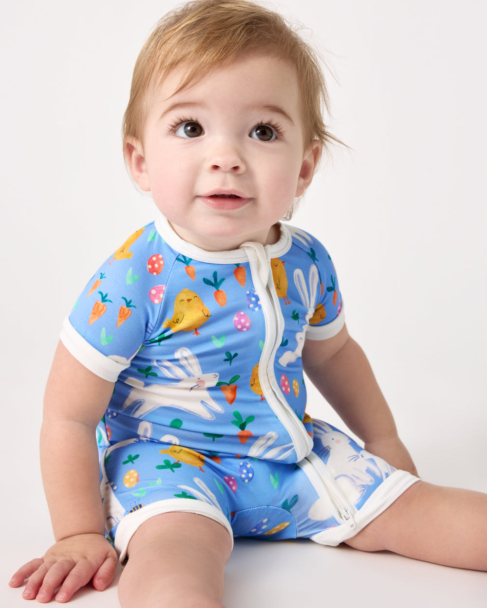 Sitting baby wearing the Bunny Patch Shorty Zippy