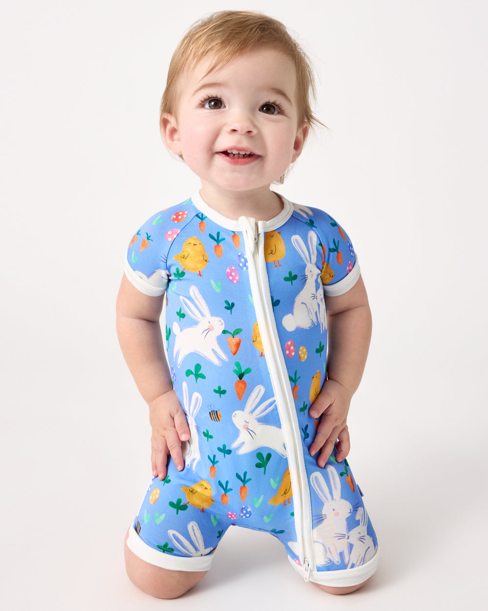 Kneeling child wearing the Bunny Patch Shorty Zippy