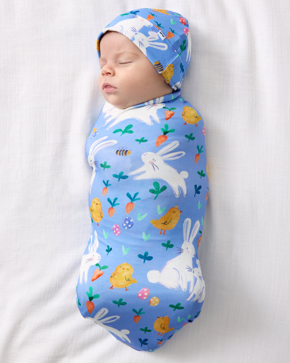 Aerial view of baby wearing the Bunny Patch Swaddle & Hat Set