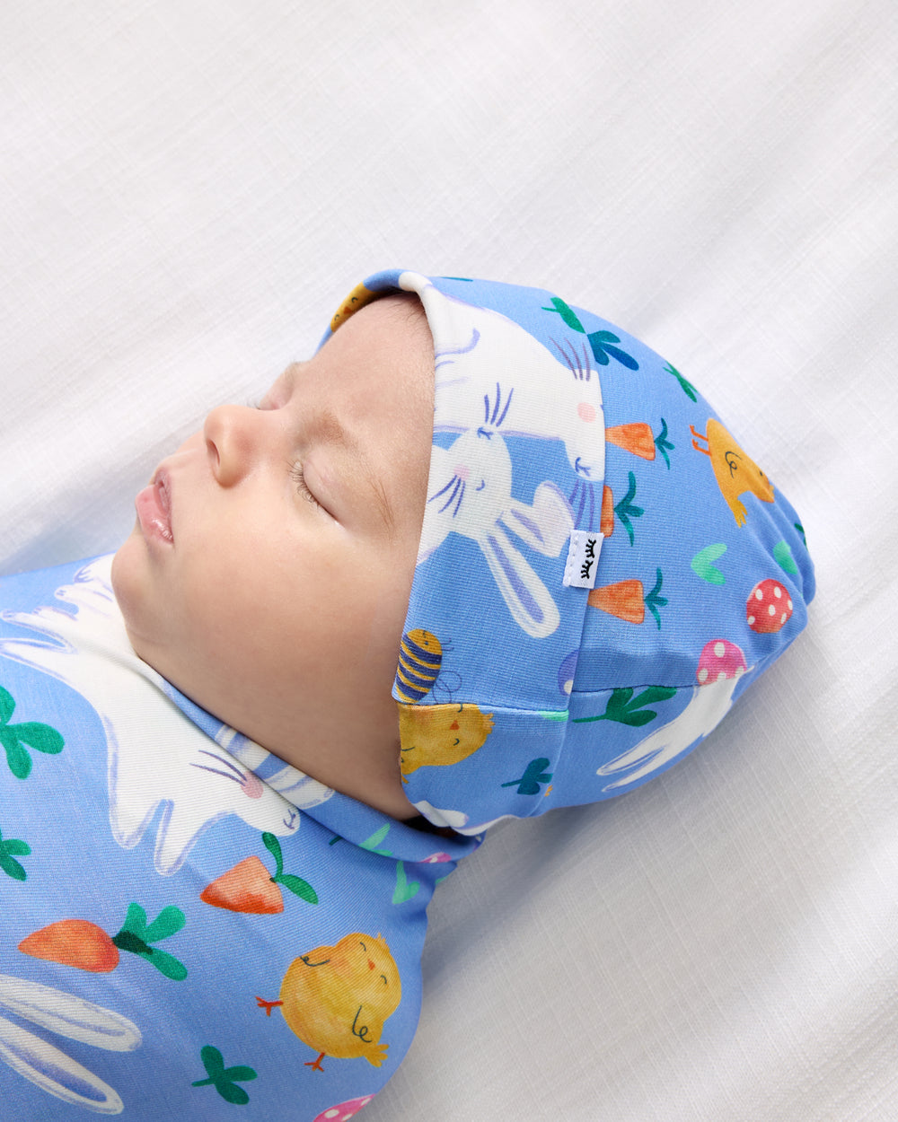 Close up of baby wearing the Bunny Patch Swaddle & Hat Set