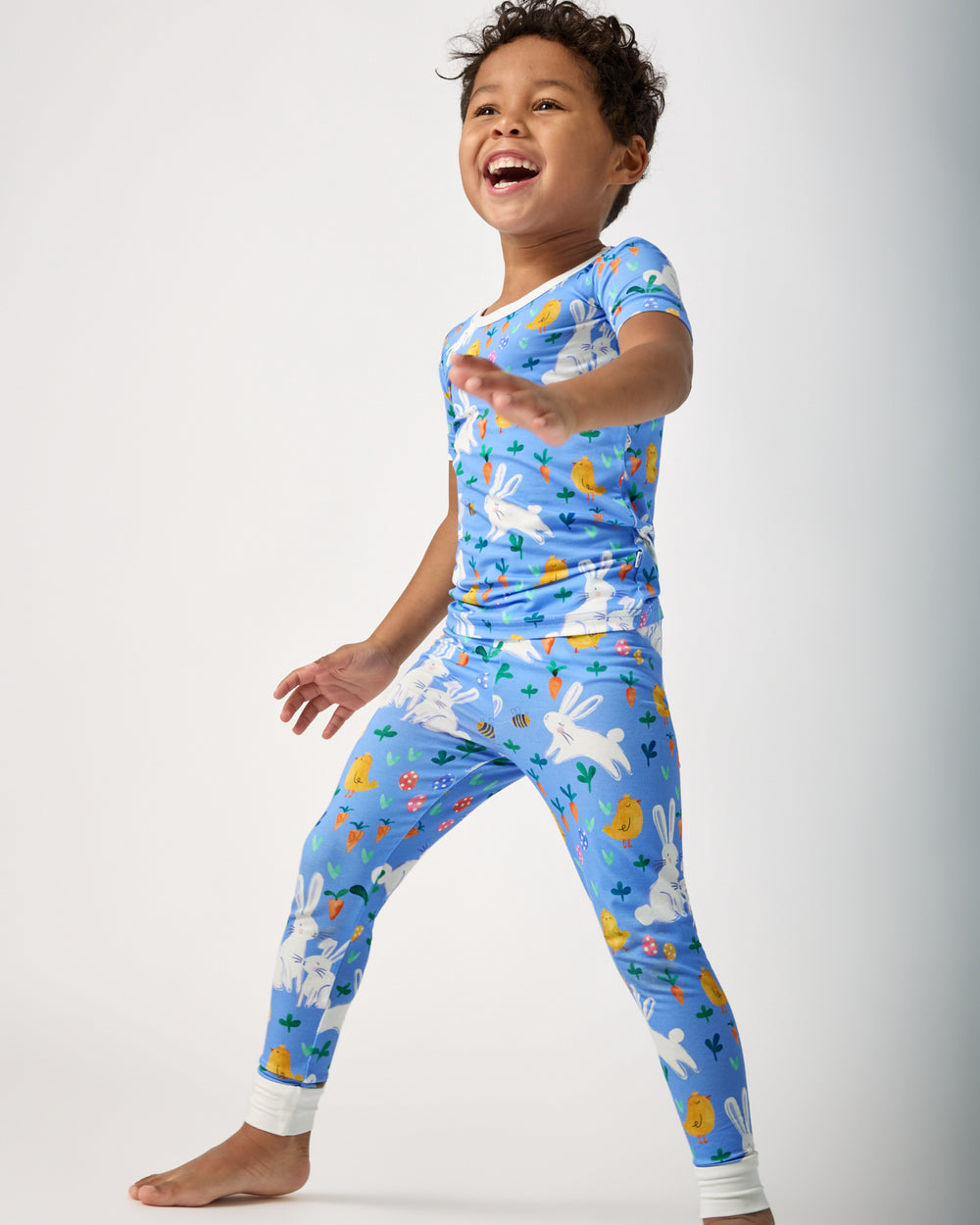 Boy in motion wearing the Bunny Patch Two-Piece Short Sleeve Pajama Set