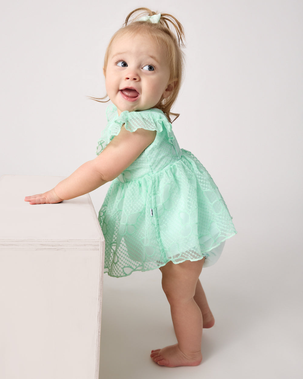 Baby wearing the Butterfly Brook Smocked Flutter Dress with Bloomer