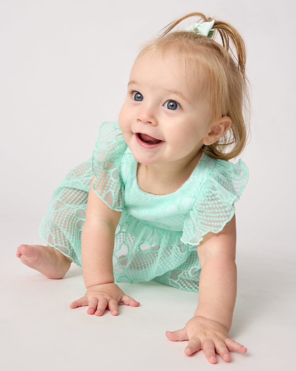 Crawling baby wearing the Butterfly Brook Smocked Flutter Dress with Bloomer