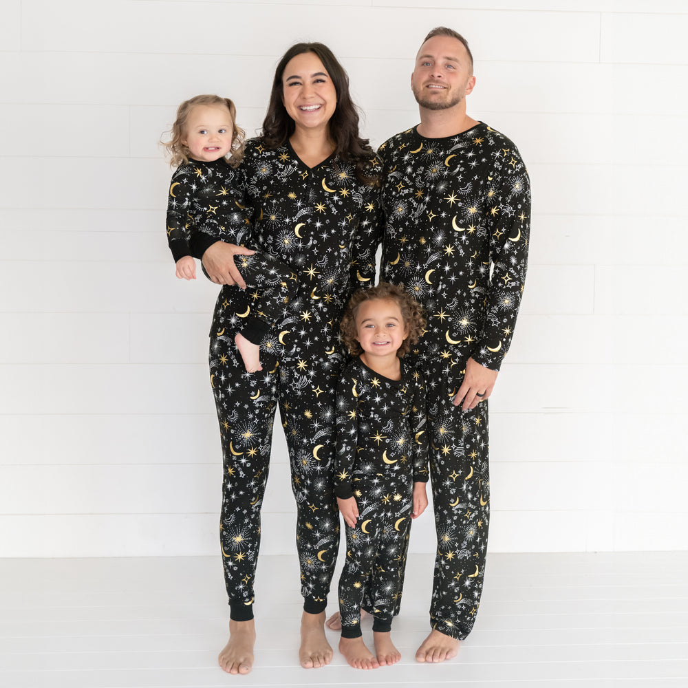 family of four posing together wearing matching Celebration Stars pjs in men's, women's and children's styles. Children are wearing zippy and two piece styles.