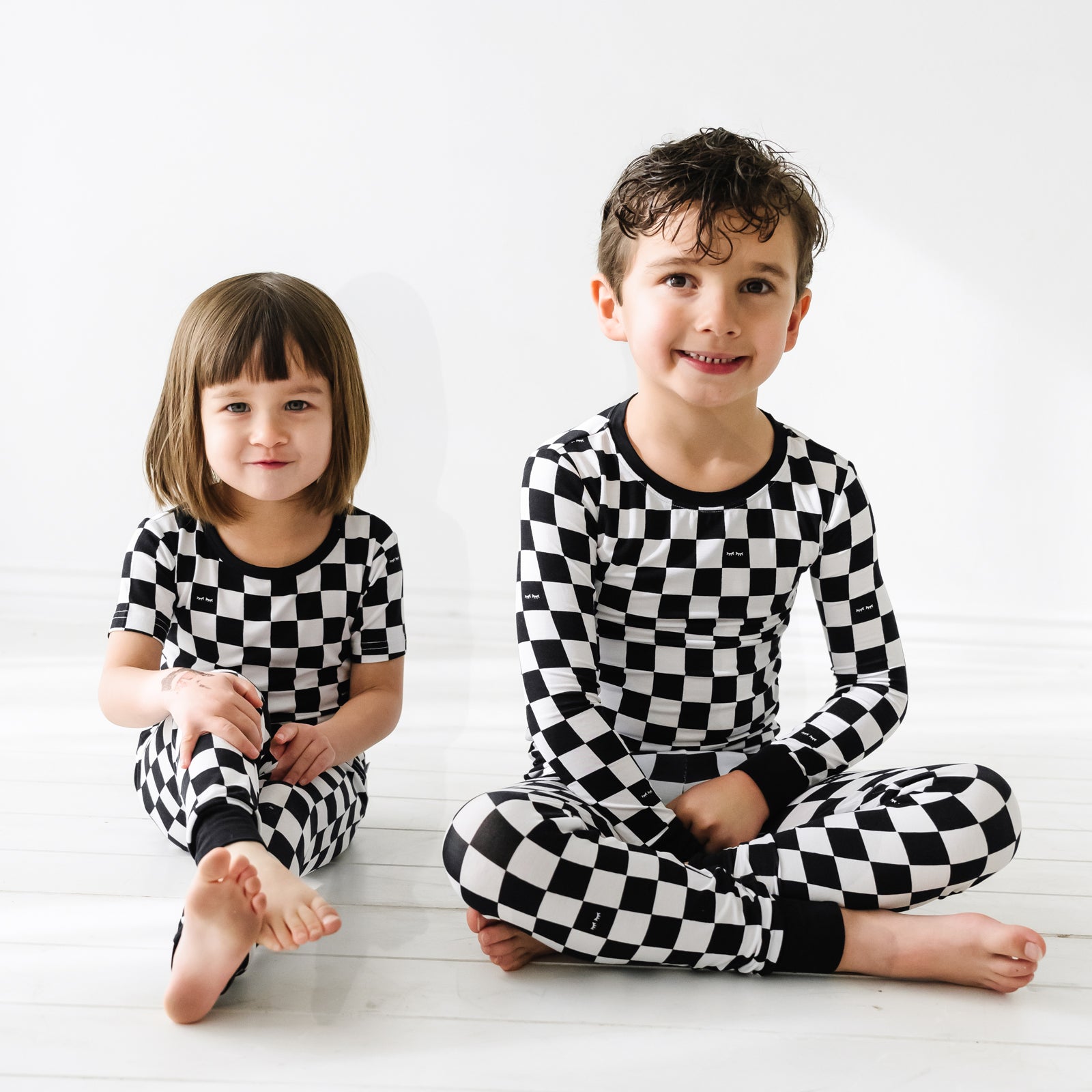 two children sitting together wearing matching Cool Checks pj sets