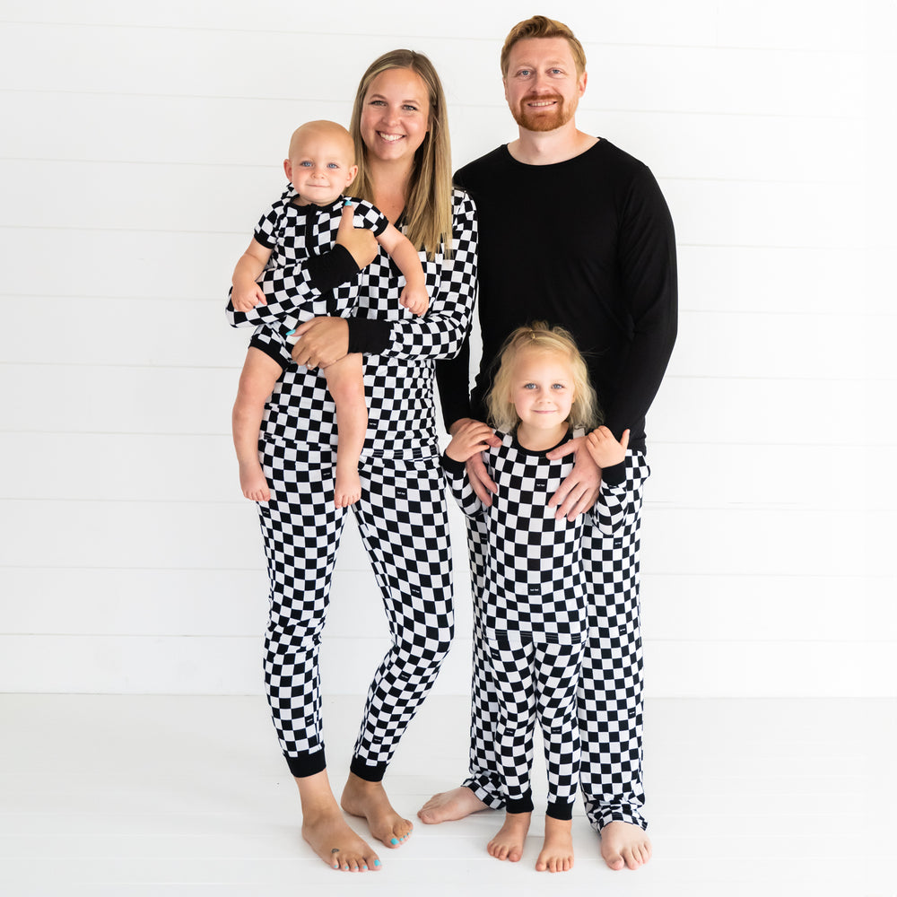 Family of four wearing matching men's, women's, and children's Cool Checks pjs. Children are wearing two piece and shorty zippy styles