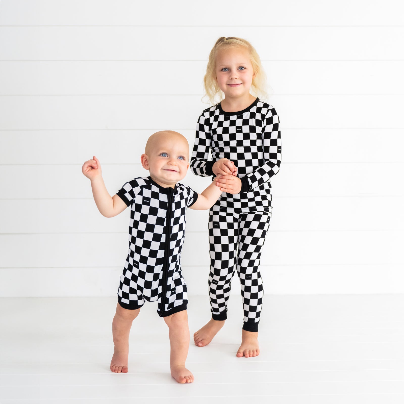 two children together wearing matching Cool Check PJs in two piece and shorty zippy style