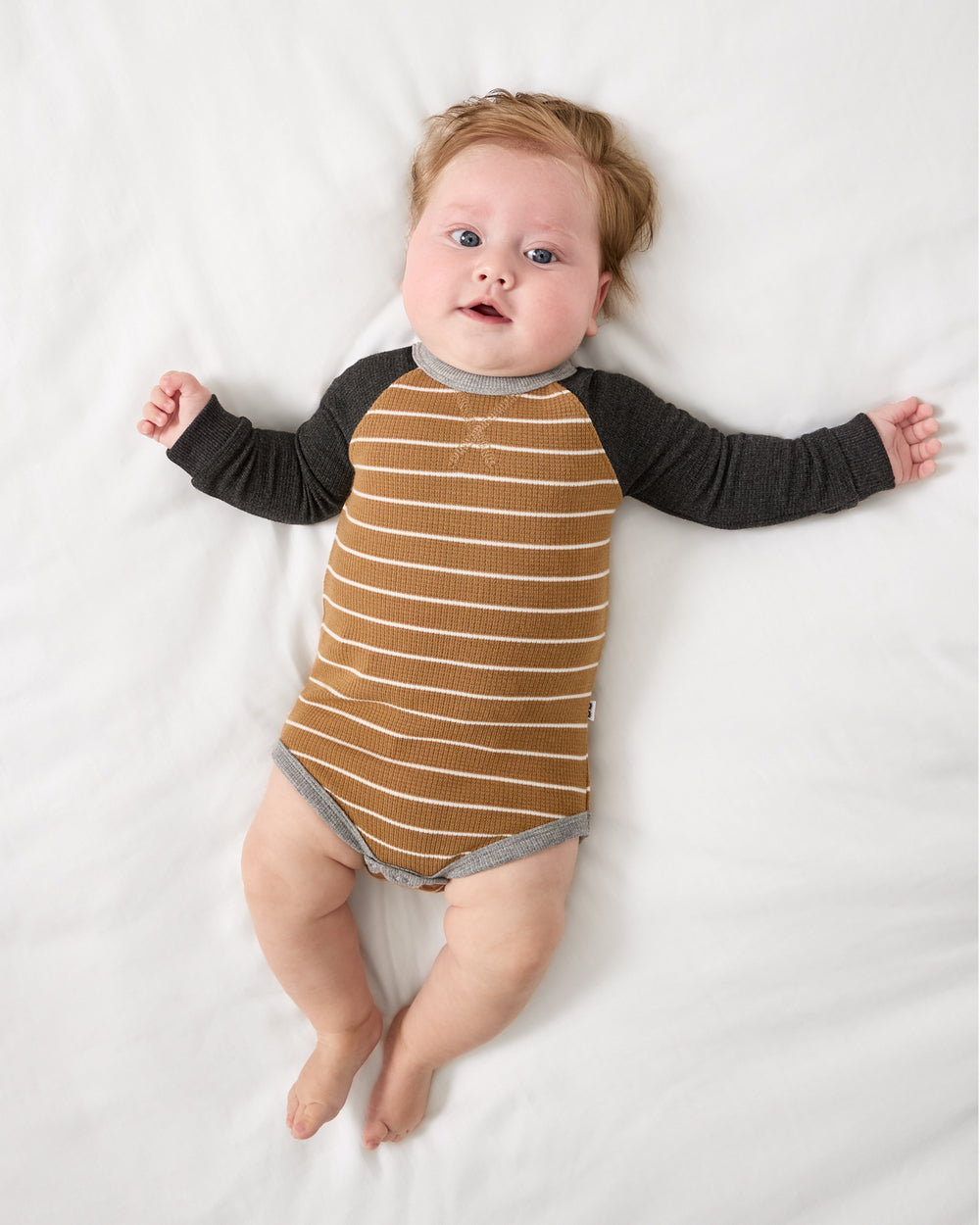 Aerial view of baby wearing the Cider Stripe Waffle Raglan Bodysuit