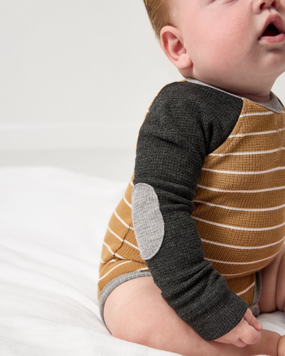 Close up of the elbow patch detail on the Cider Stripe Waffle Raglan Bodysuit