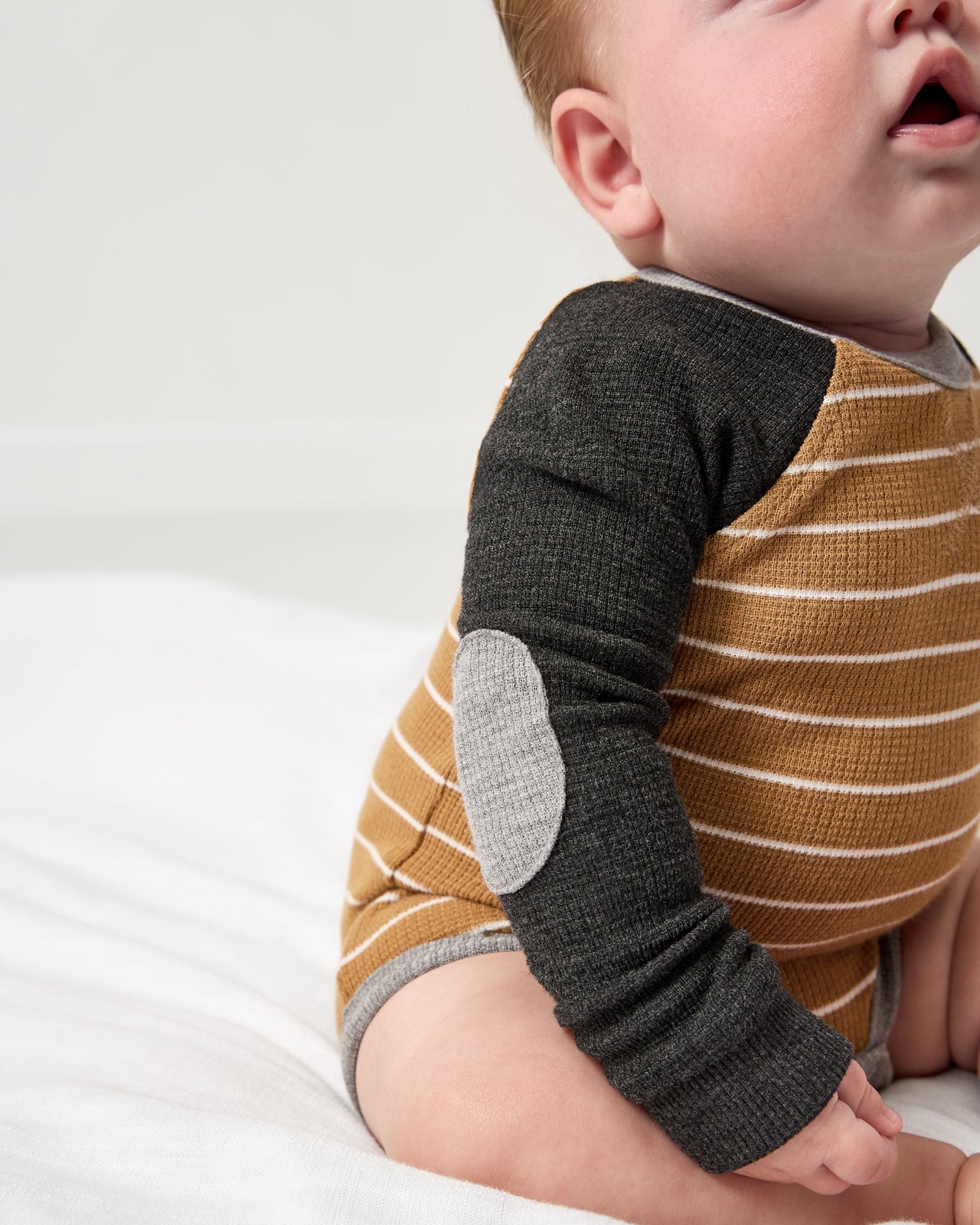 Close up of the elbow patch detail on the Cider Stripe Waffle Raglan Bodysuit