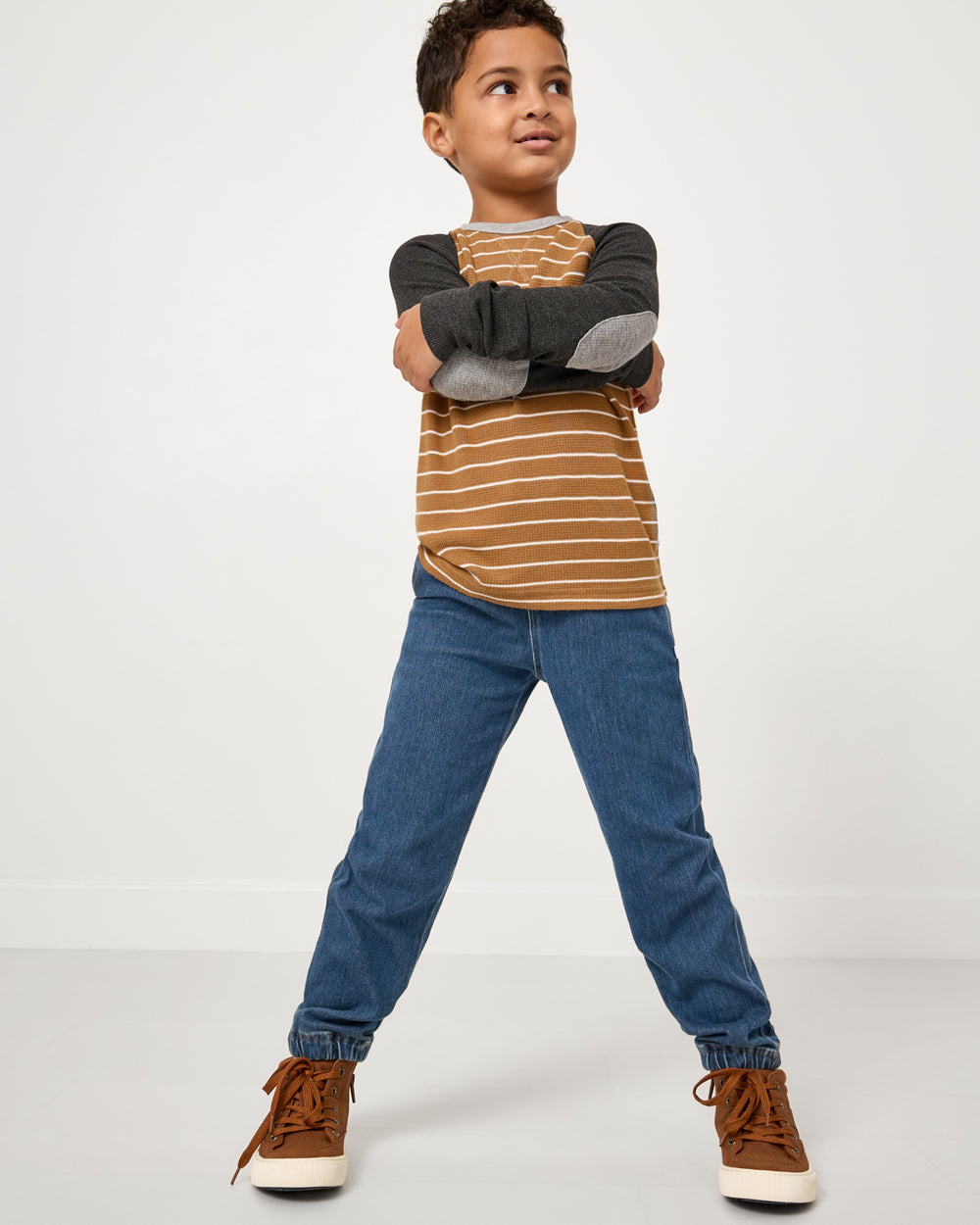 Boy wearing the Cider Stripe Waffle Raglan Tee with denim joggers