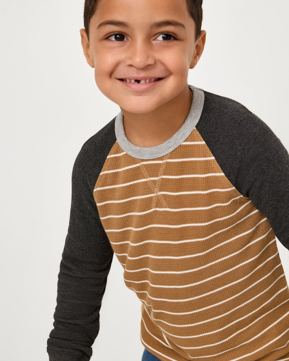 Close up of boy wearing the Cider Stripe Waffle Raglan Tee