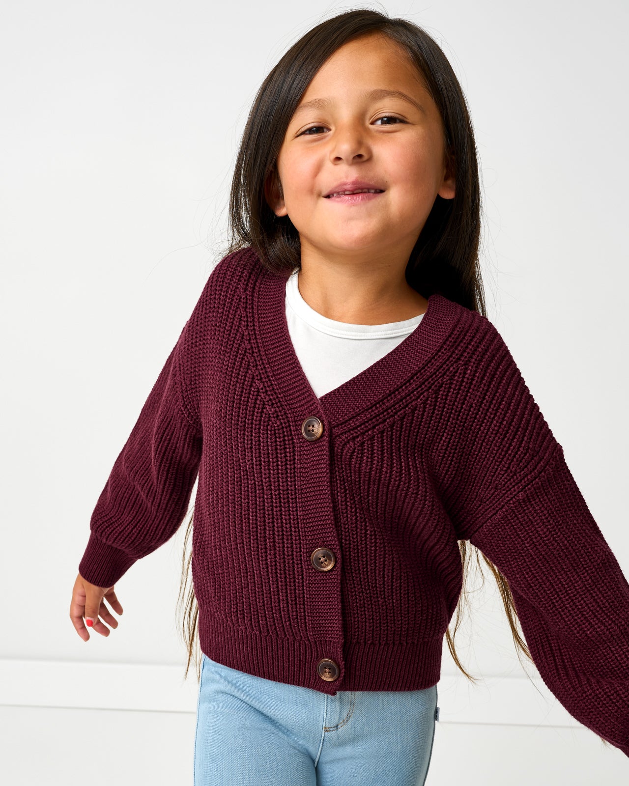 Girl wearing the Classic Burgundy Cropped Sweater layered over a white tee