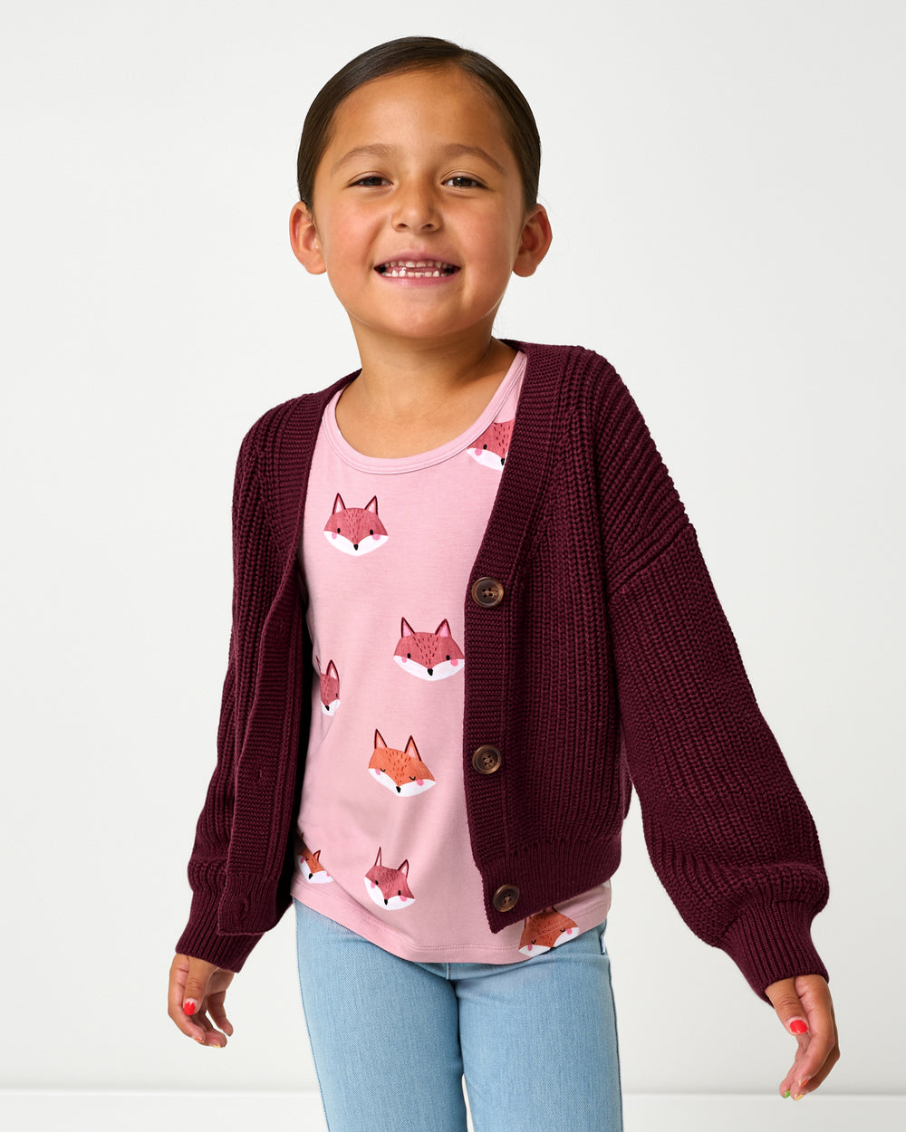 Girl wearing the Classic Burgundy Cropped Sweater layered over a fox print tee