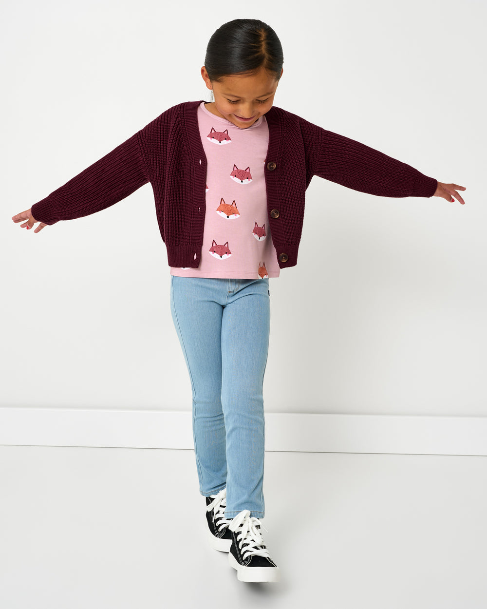 Girl wearing the Classic Burgundy Cropped Sweater with denim pants