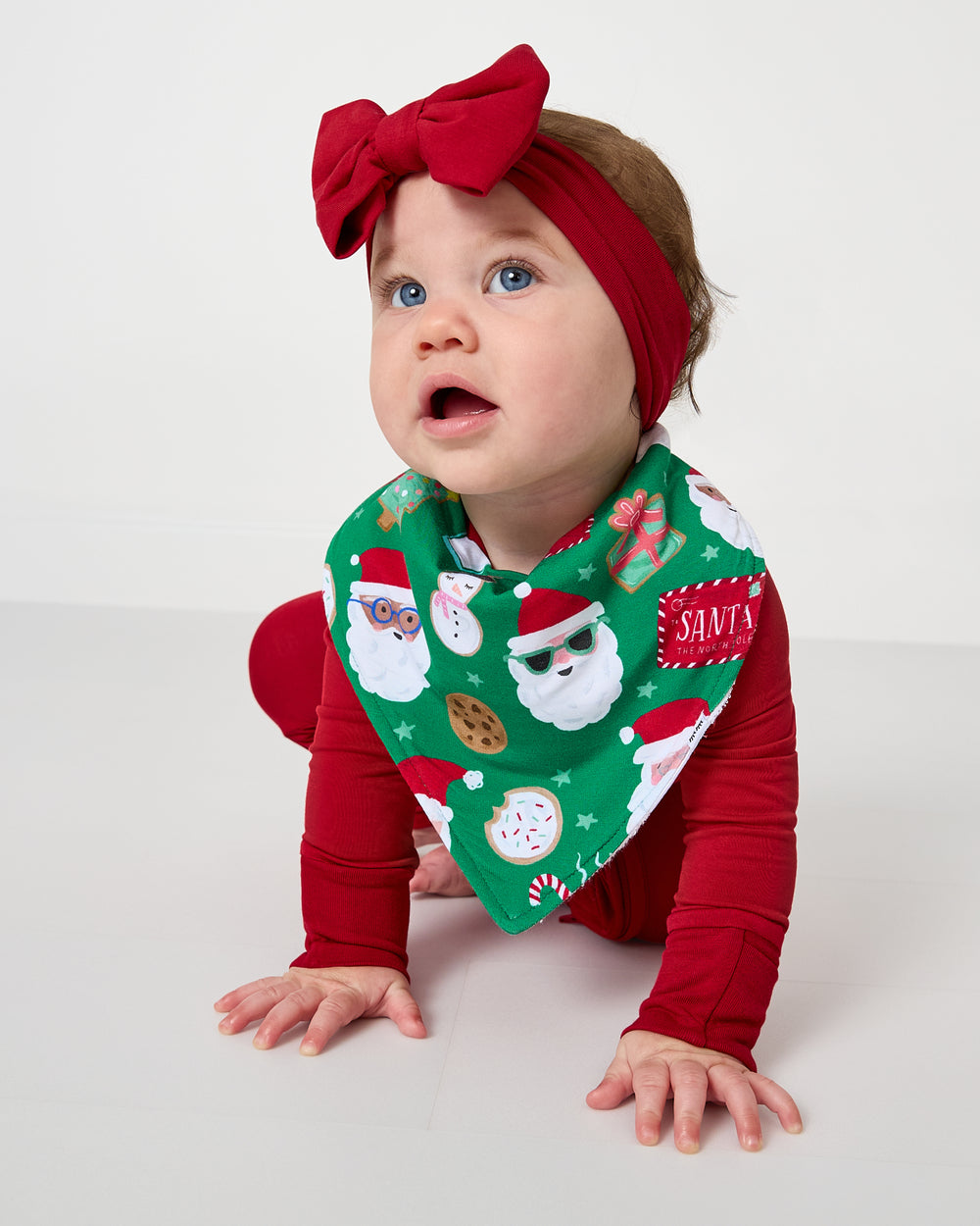 Crawling baby wearing the Cookies for Santa Bandana Bib