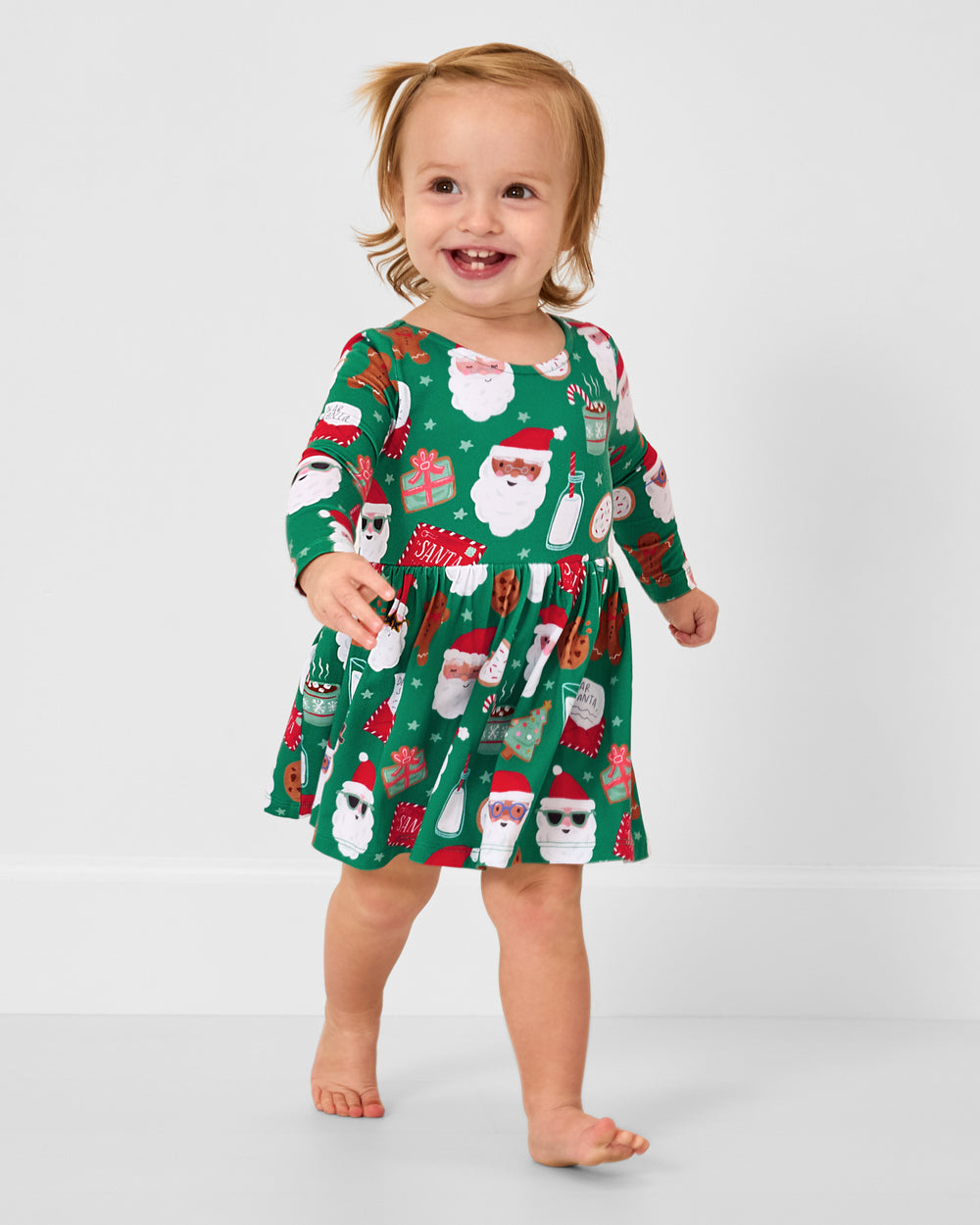 Walking toddler wearing the Cookies for Santa Bow Back Skater Dress with Bodysuit
