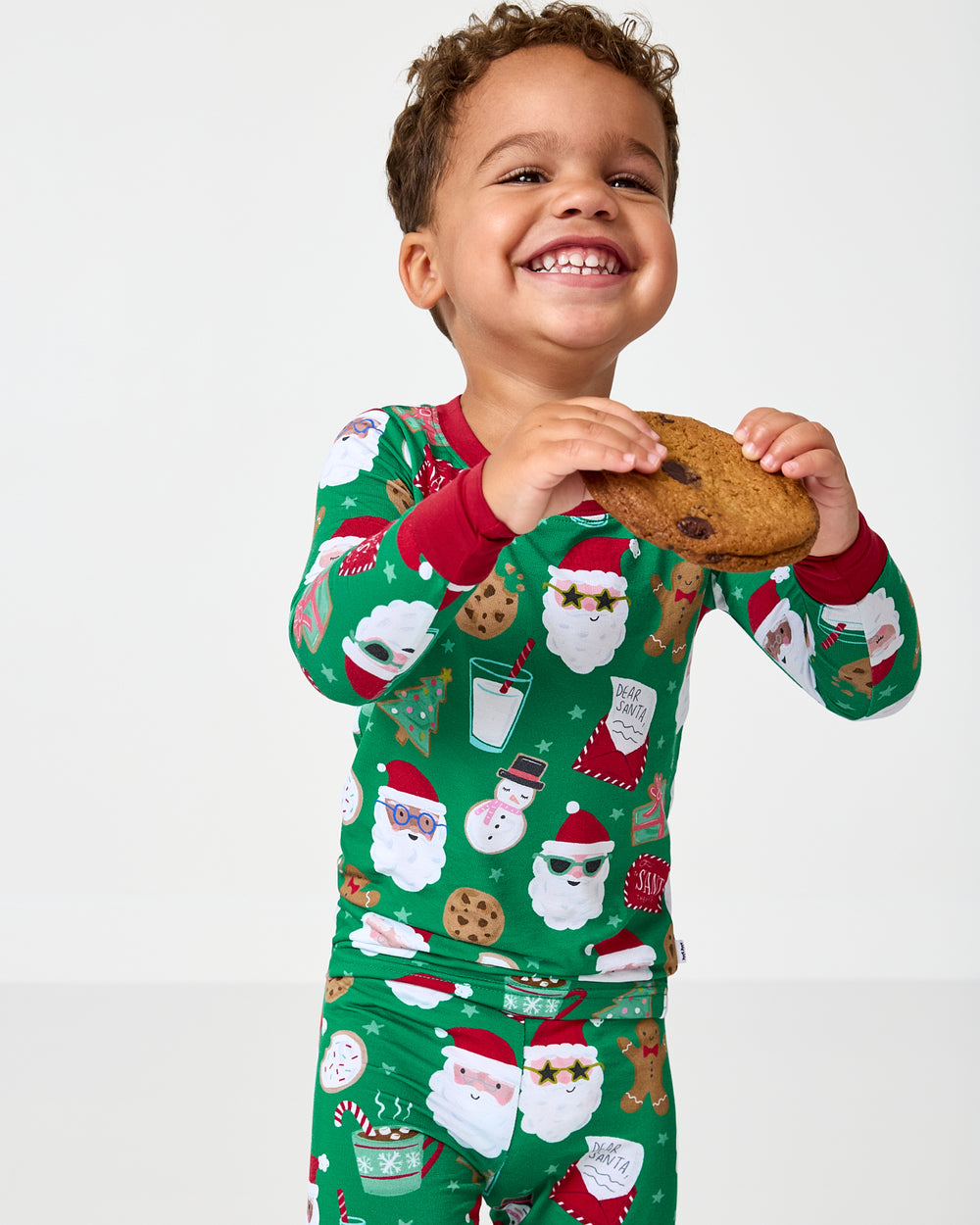 Child holding a cookies wearing the Cookies for Santa Two-Piece Pajama Set
