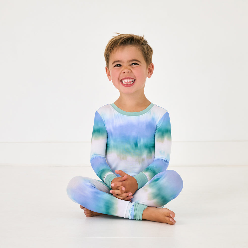 Sitting child wearing the Blue Cosmic Mist Two-Piece Pajama Set