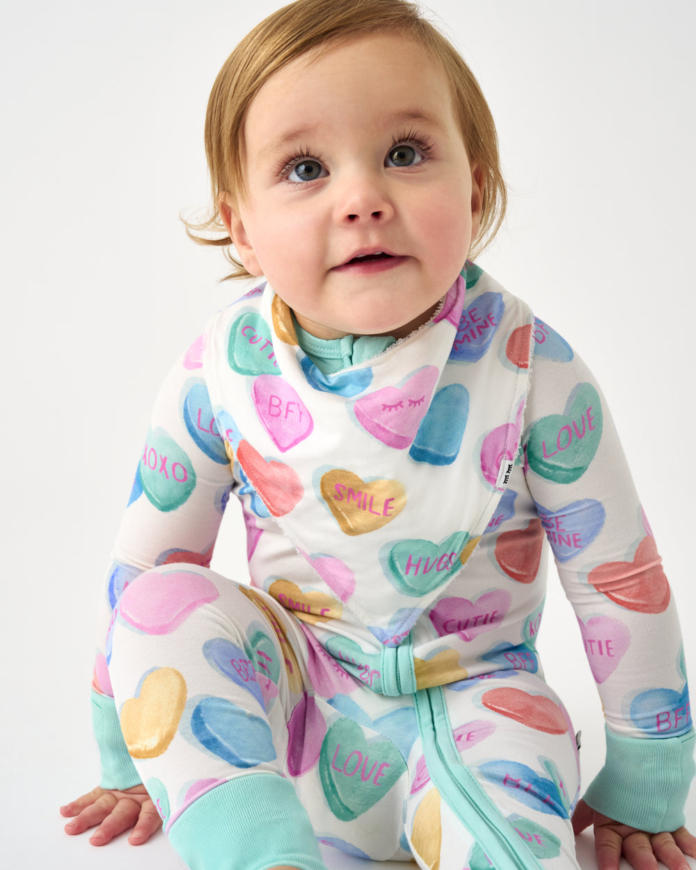 Sitting baby wearing the Candy Cuties Bandana Bib