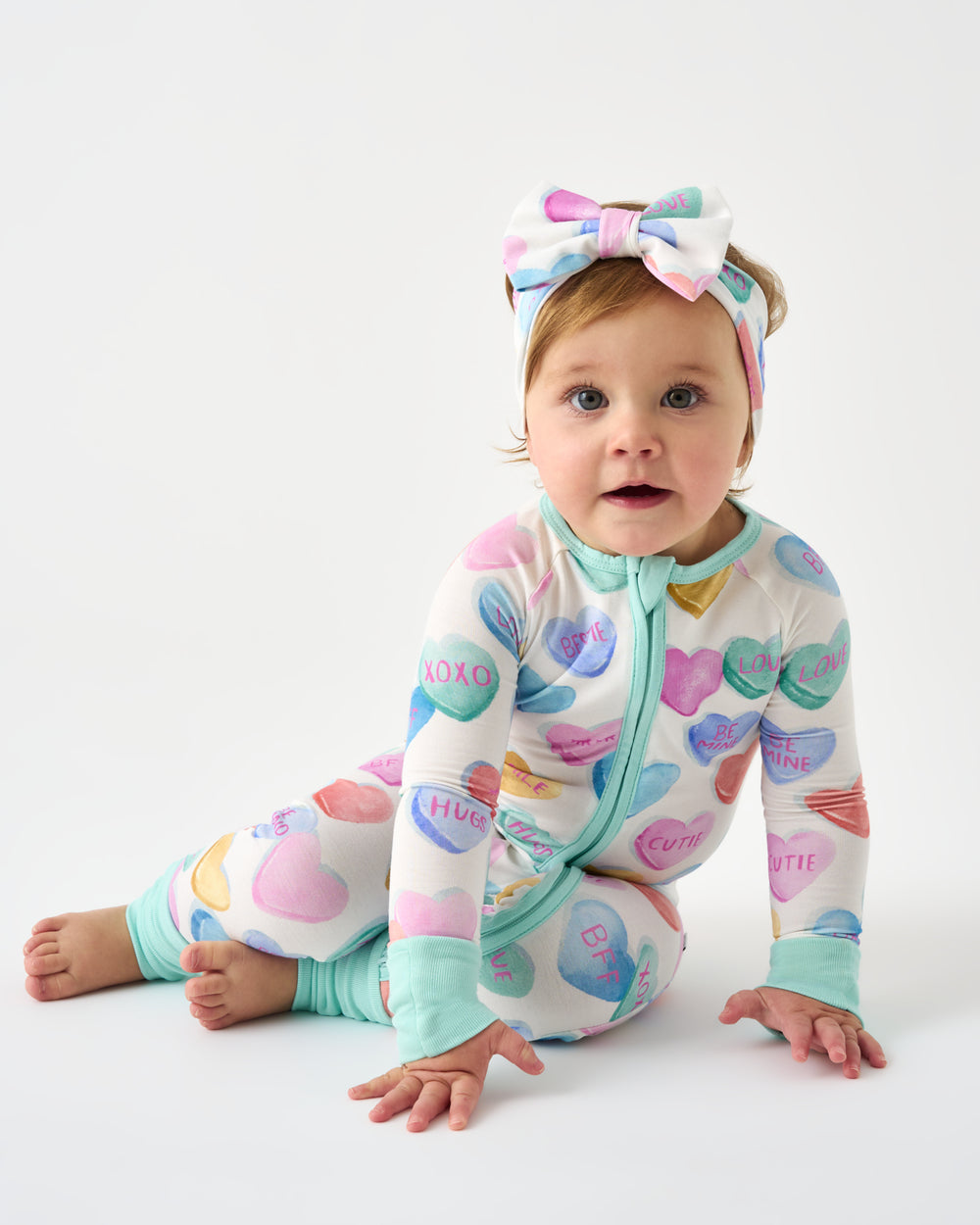 Baby wearing the Candy Cuties Luxe Bow Headband and Zippy