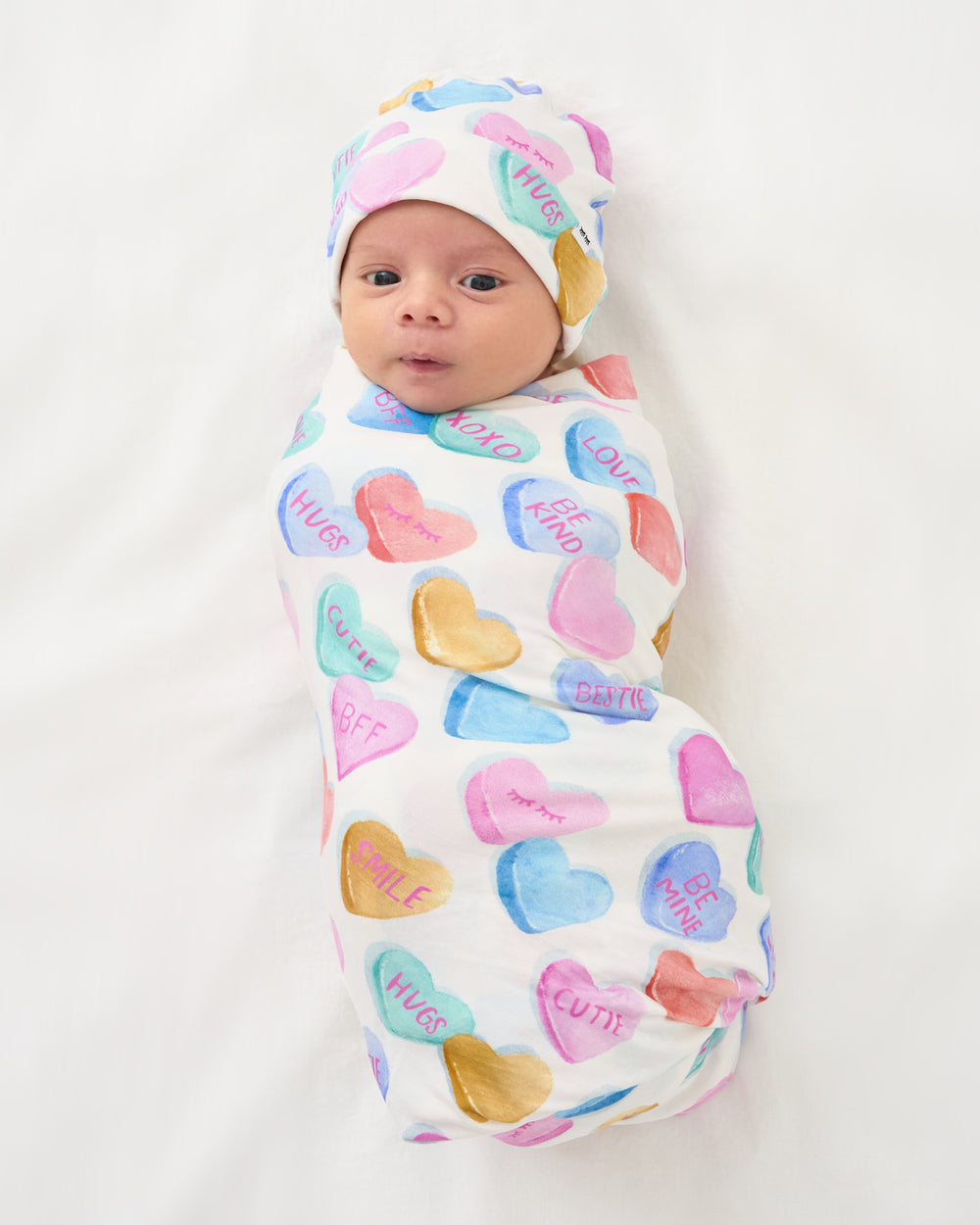 Aerial view of baby swaddled in the Candy Cuties Swaddle & Hat Set