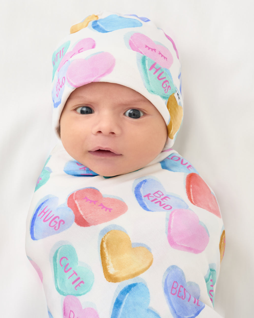 Close up of baby swaddled in the Candy Cuties Swaddle & Hat Set