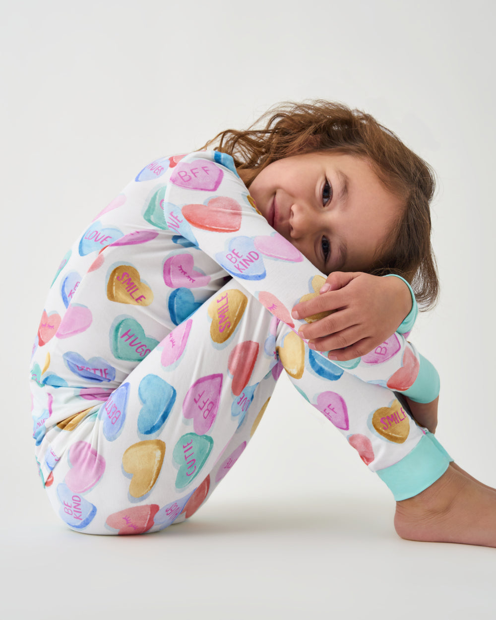 Sitting girl wearing the Candy Cuties Two-Piece Pajama Set