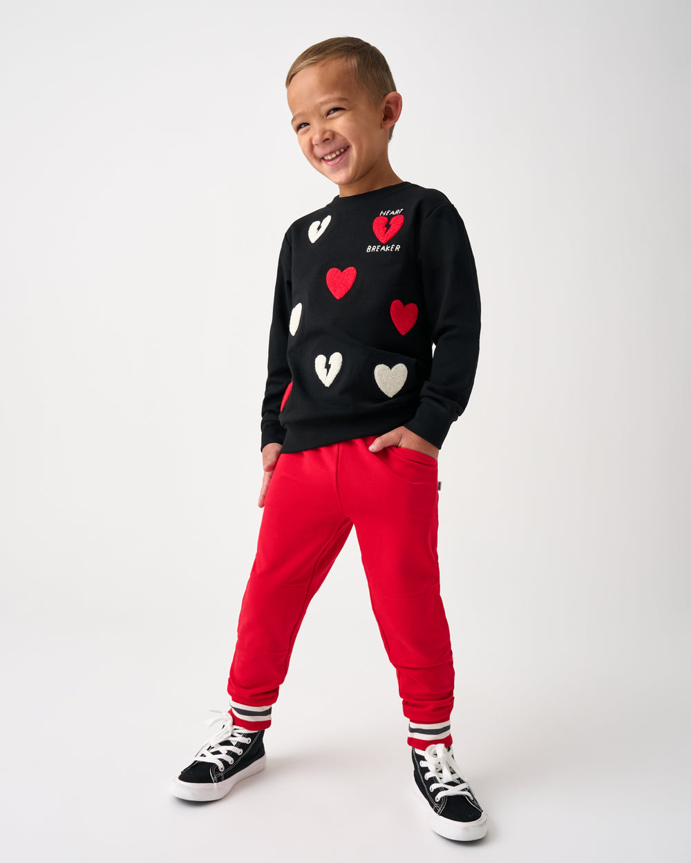 Boy wearing the Rebel Hearts Crewneck Sweatshirt and Red Joggers