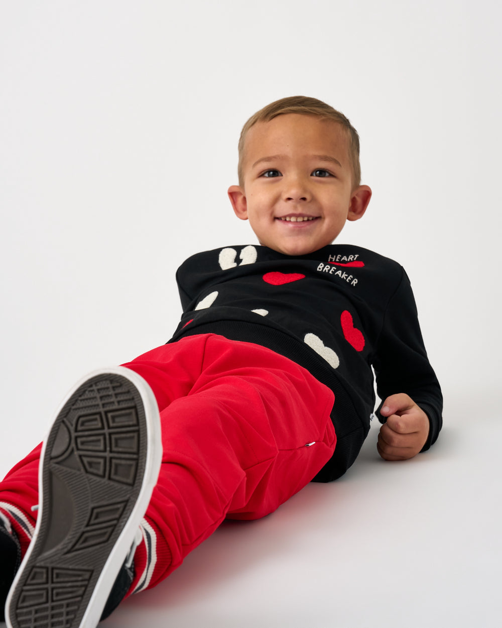 Boy wearing the Candy Red Jogger on a white background