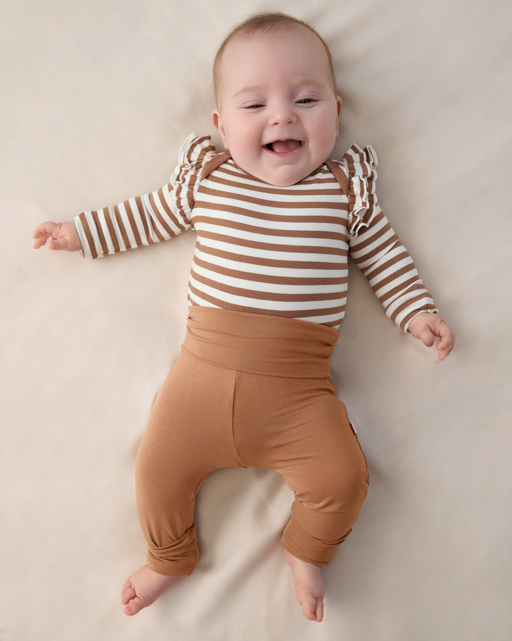 Baby wearing the Chestnut Brown Fold Over Legging with a striped bodysuit