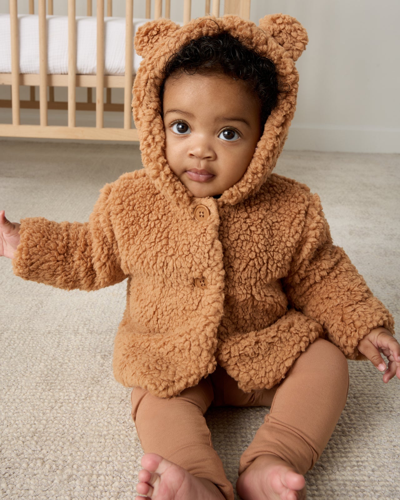 Sitting baby wearing the Chestnut Brown Sherpa Baby Jacket and leggings