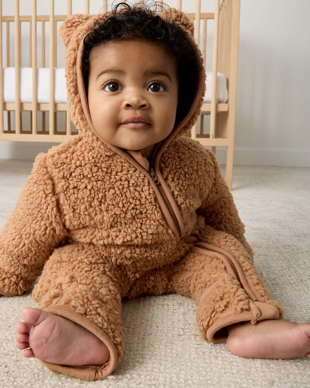 Sitting baby wearing the Chestnut Brown Sherpa Baby Romper