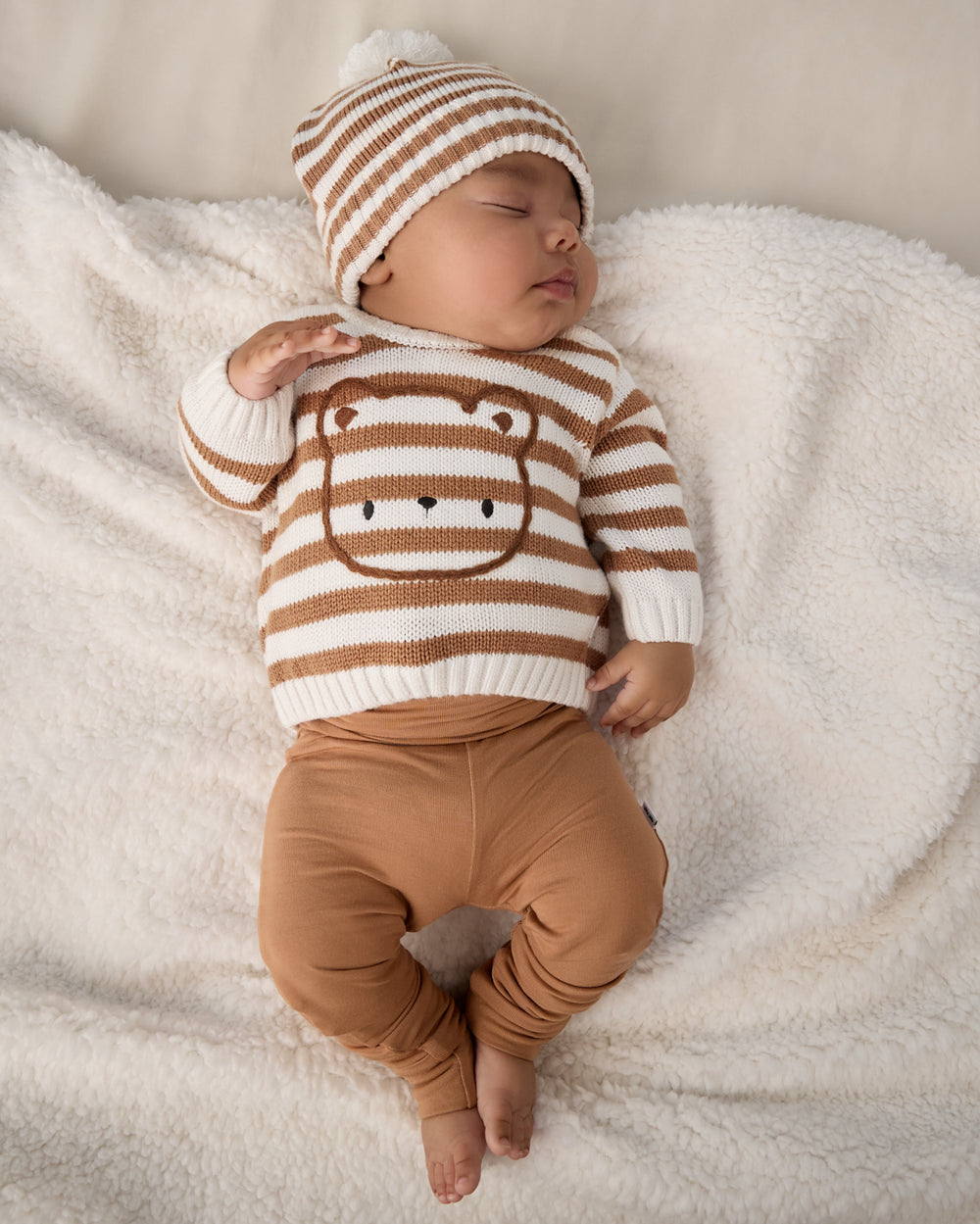 Newborn wearing the Chestnut Brown Fold Over Legging with a striped sweater