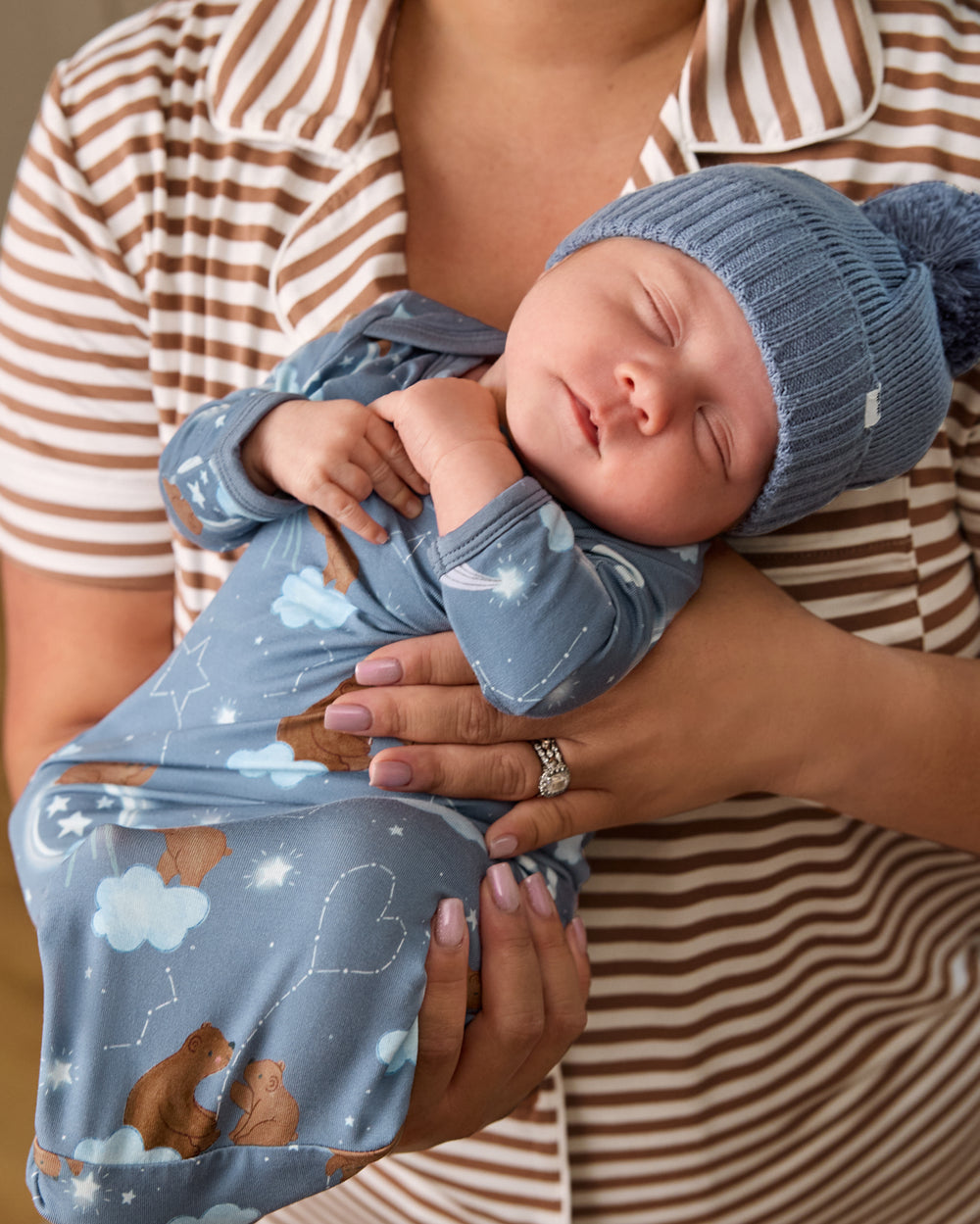 Mother holding baby wearig the Constellation Cubs Infant Gown and Blue Beanie