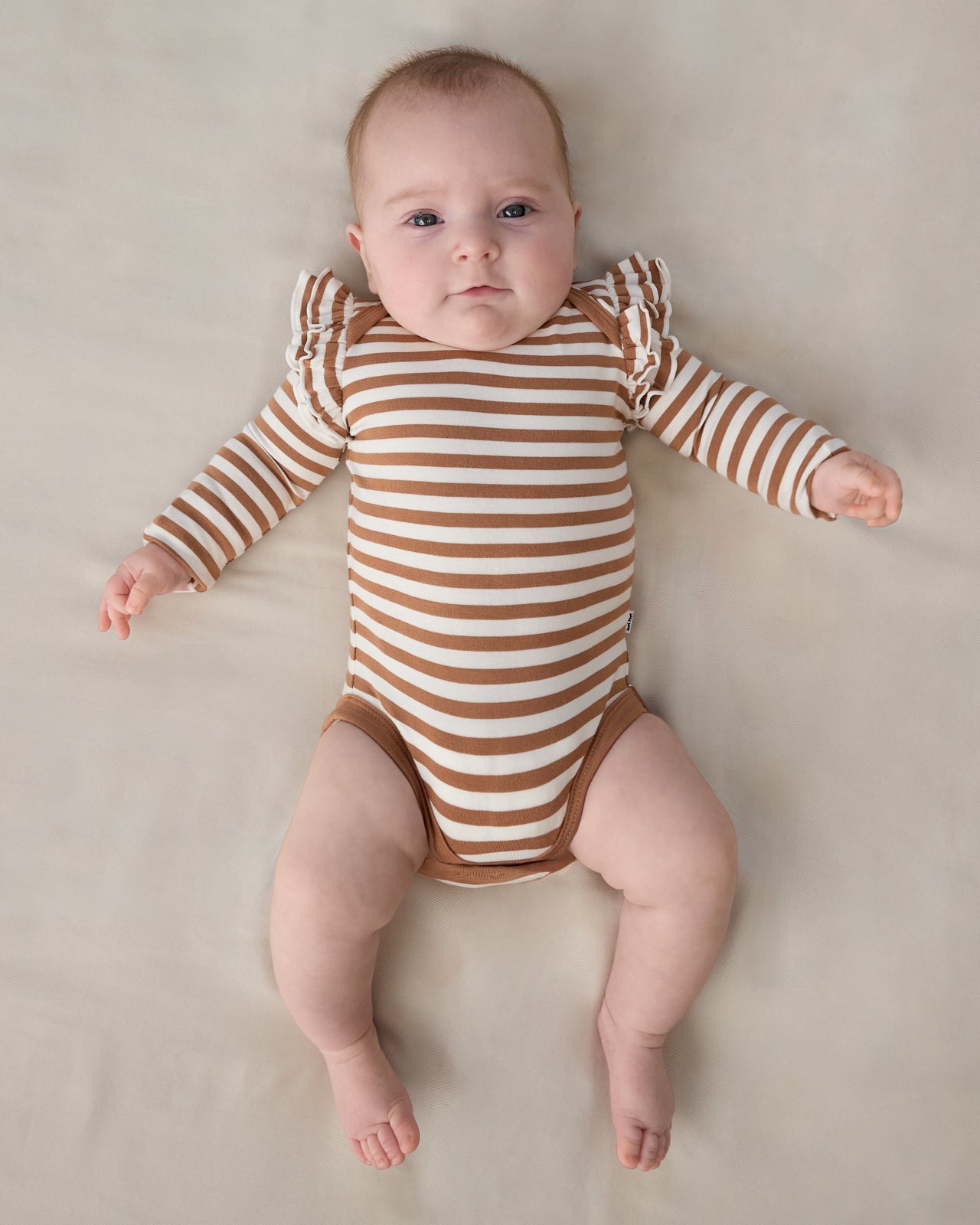 Aerial view of baby wearing the Chestnut Brown Stripe Flutter Bodysuit