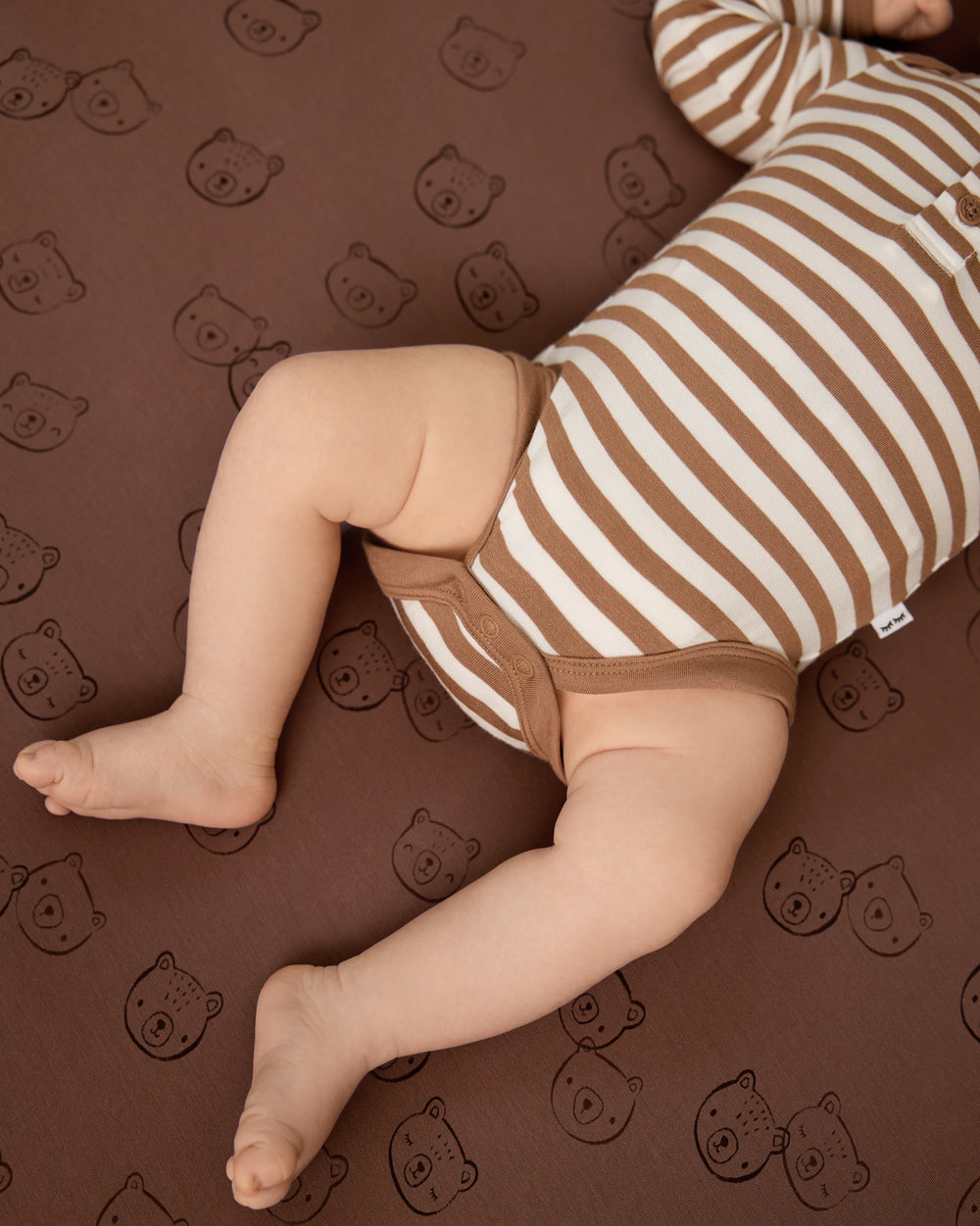 Close up of the snap button detail on the Chestnut Brown Stripe Henley Bodysuit