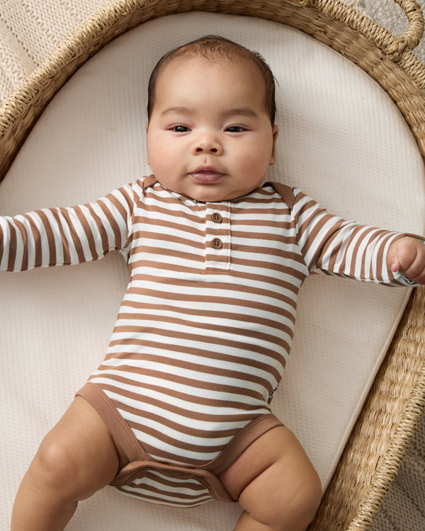Newborn wearing he Chestnut Brown Stripe Henley Bodysuit in a woven basket
