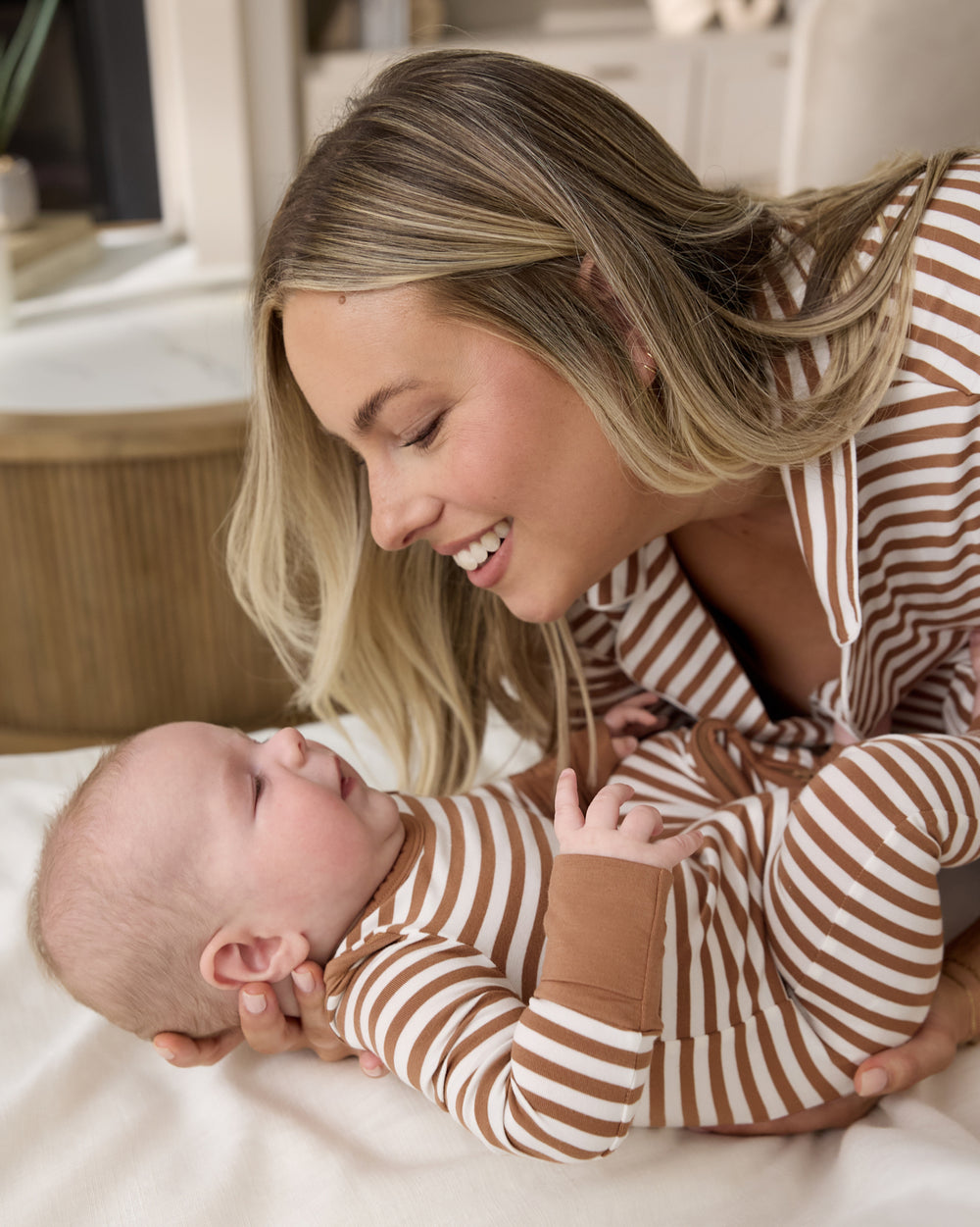 Mother holding newborn wearing the Chestnut Brown Stripe Crescent Zippy