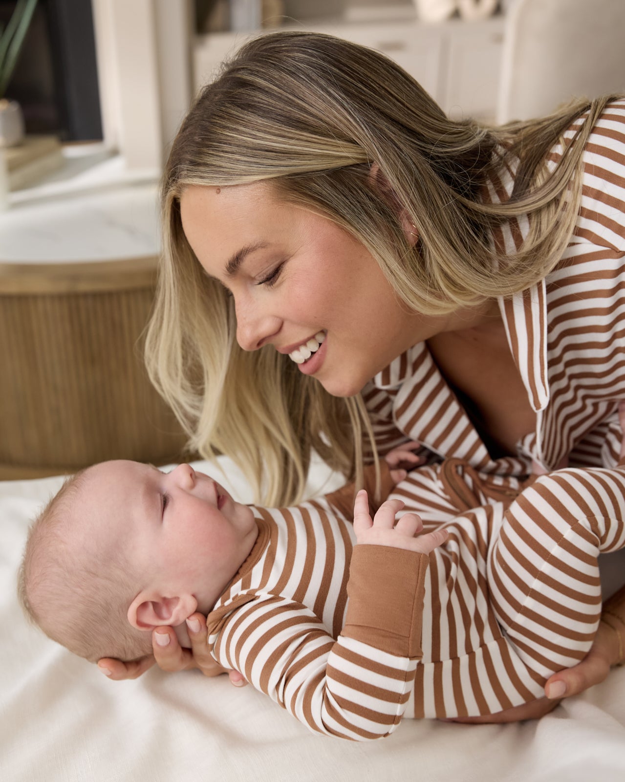Mother holding newborn wearing the Chestnut Brown Stripe Crescent Zippy