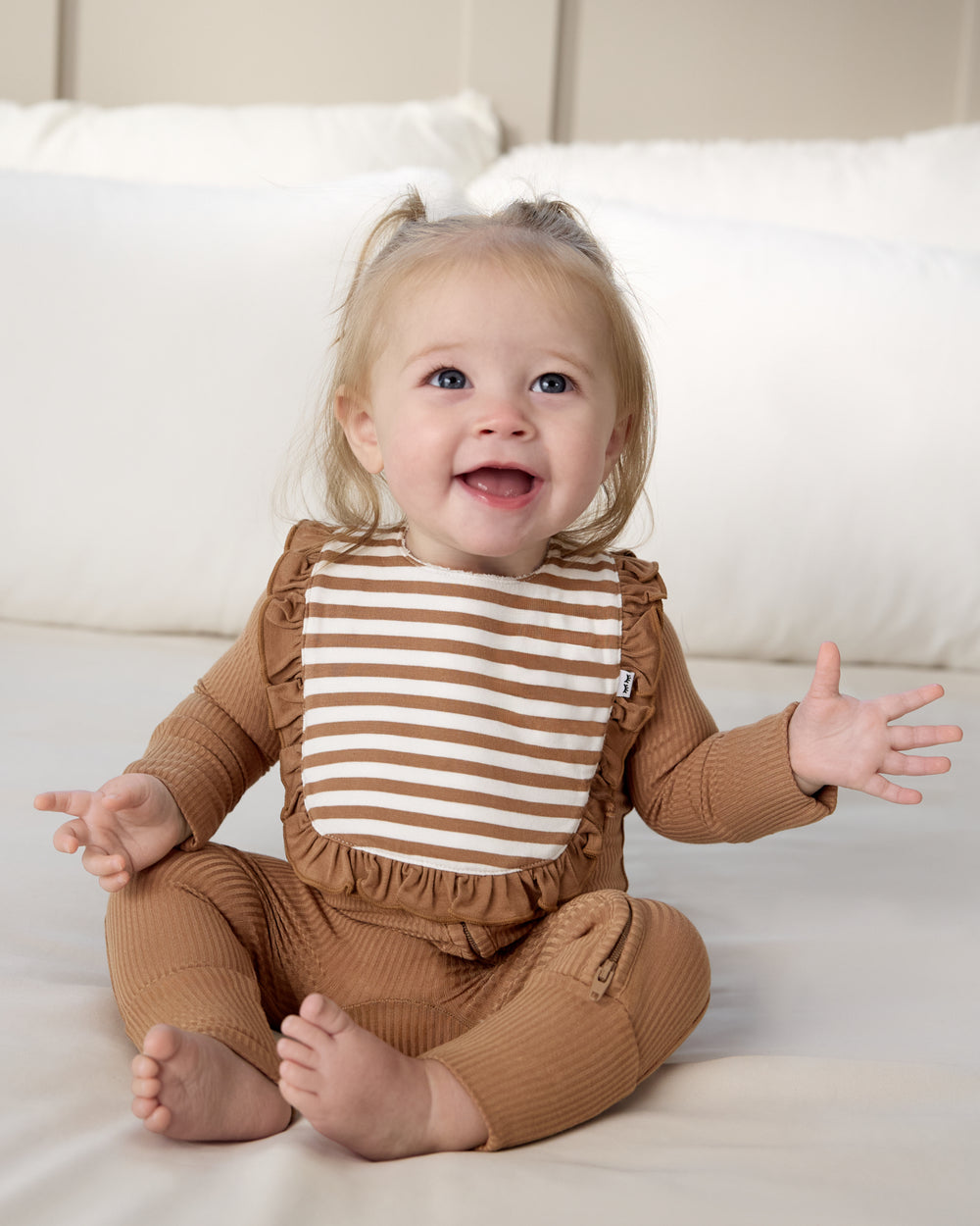 Sitting baby wearing the Chestnut Brown Stripe Ruffle Bib