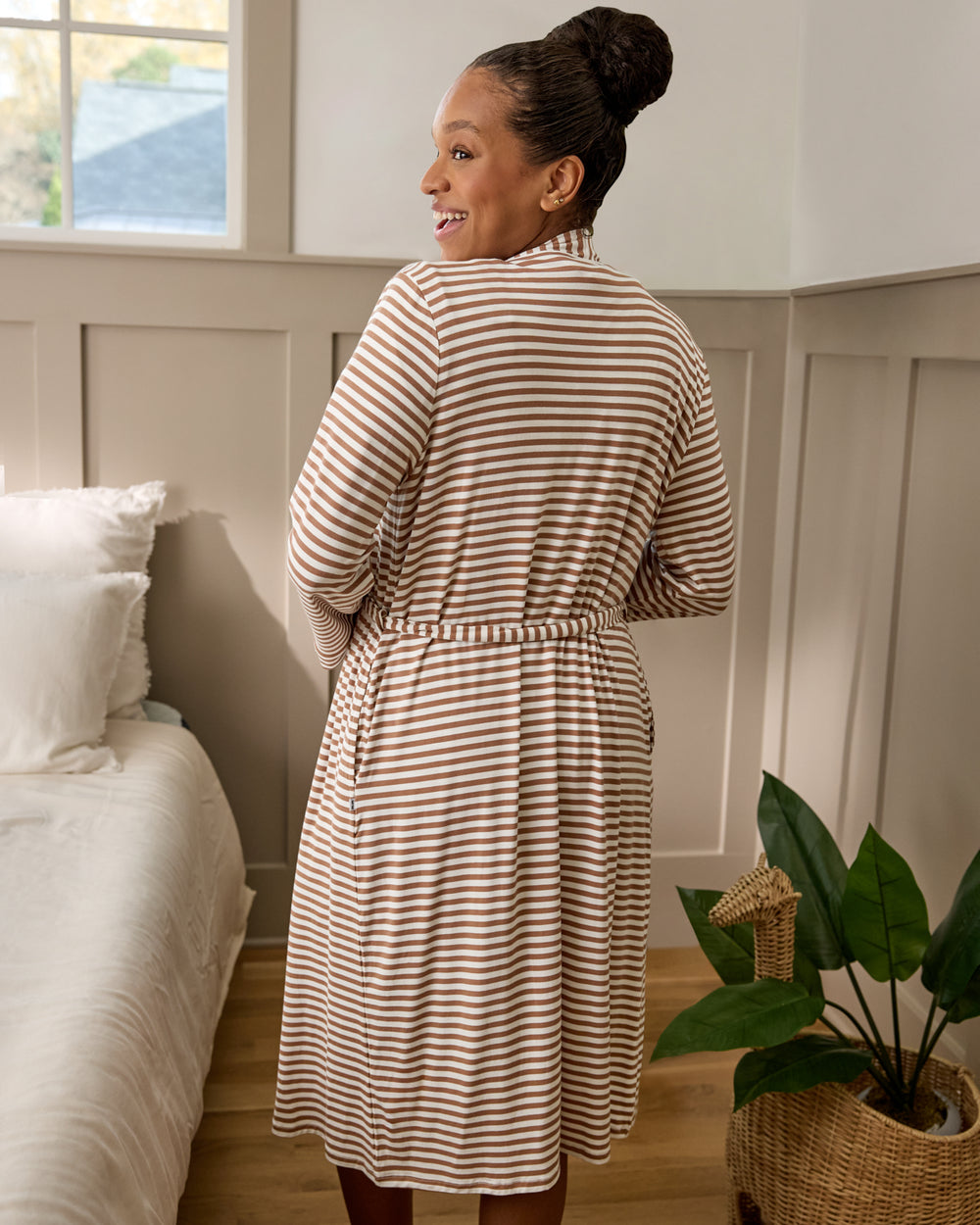 Back view of woman wearing the Chestnut Brown Stripe Women's Robe in a bedroom