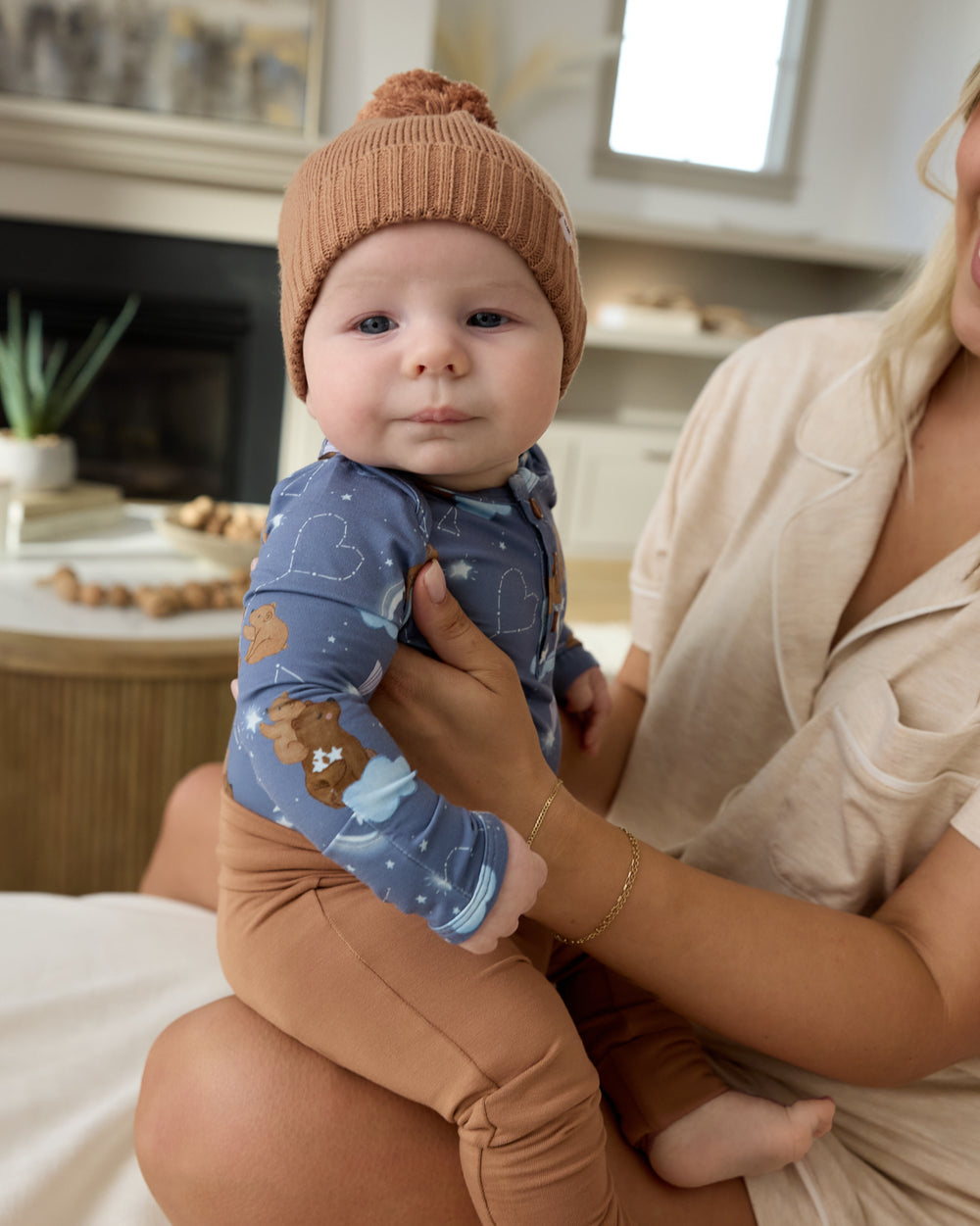 Newborn on mothers lap wearing the Constellation Cubs Henley Bodysuit