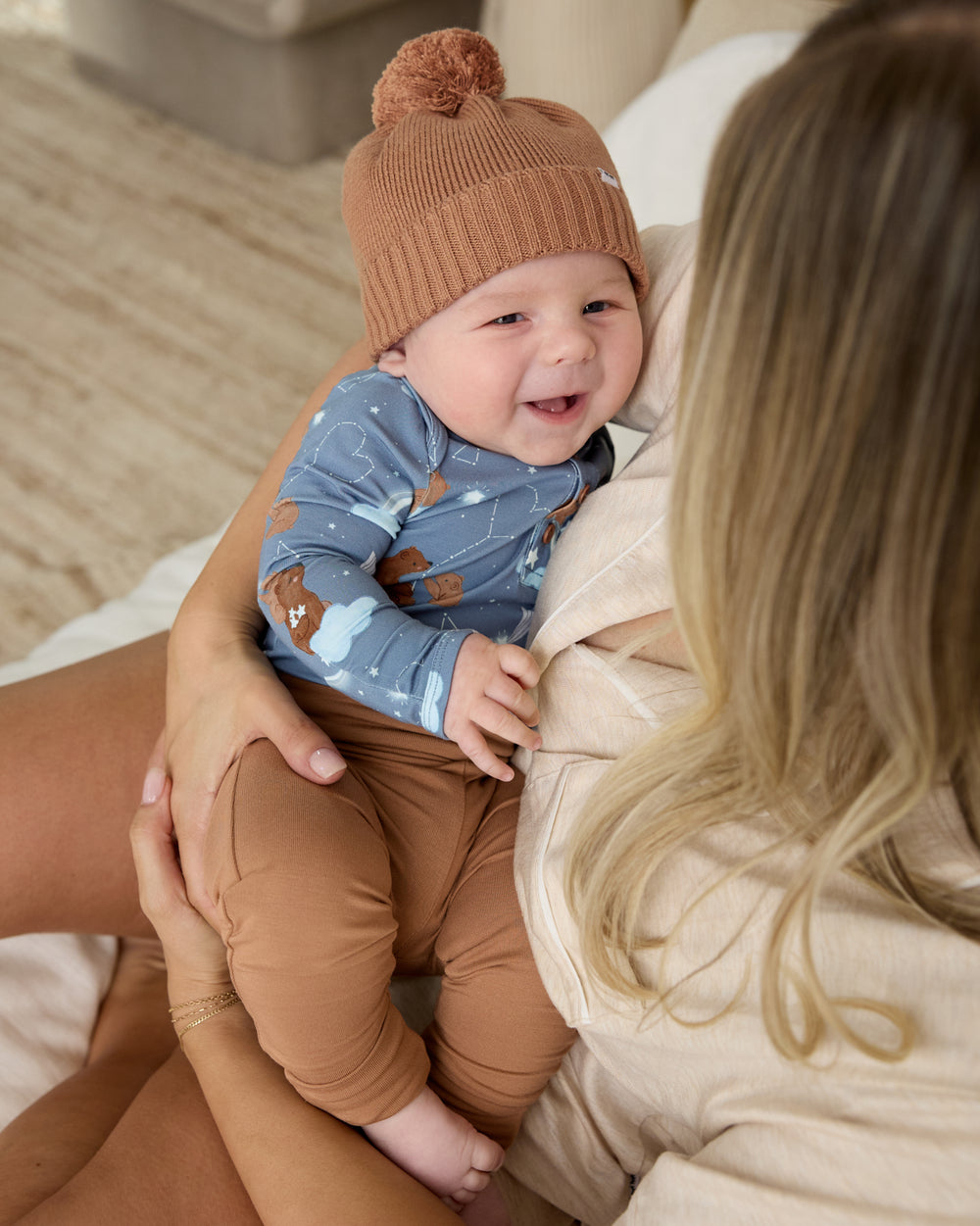 Mother holding newborn wearing the Chestnut Brown Sweater Beanie Hat