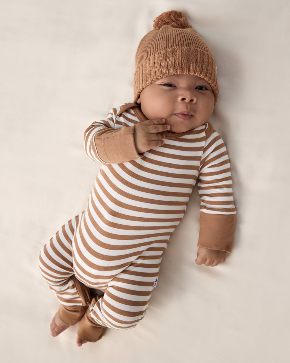Baby wearing the Chestnut Brown Sweater Beanie Hat and Striped Zippy