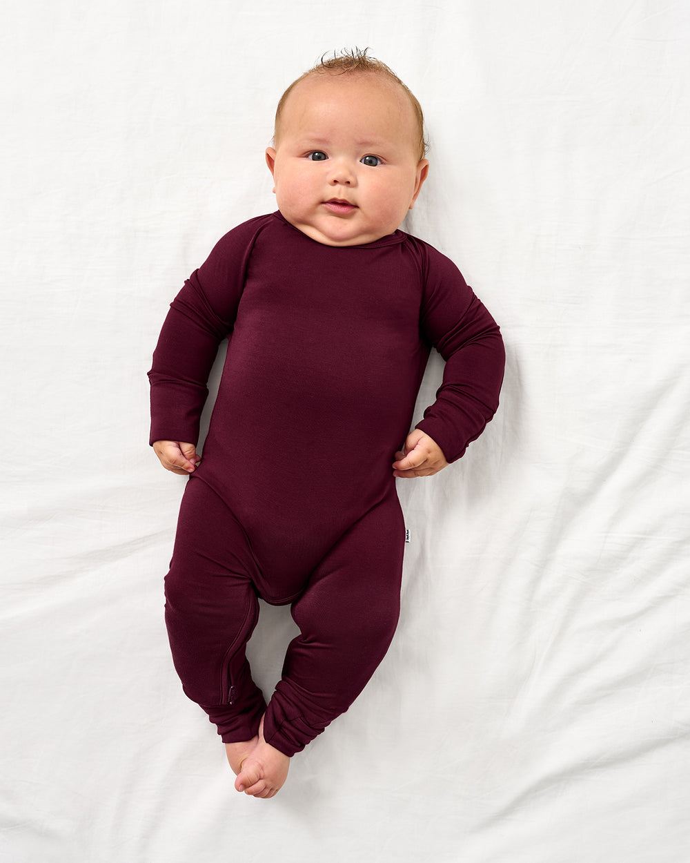 Aerial view of baby wearing the Classic Burgundy Crescent Zippy