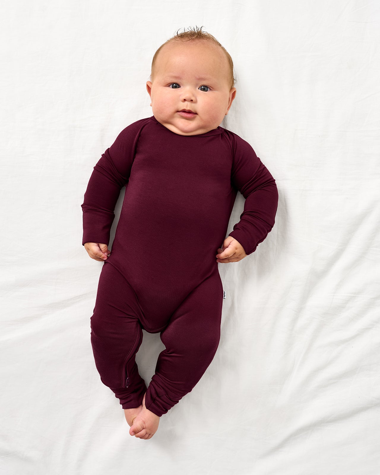 Aerial view of baby wearing the Classic Burgundy Crescent Zippy
