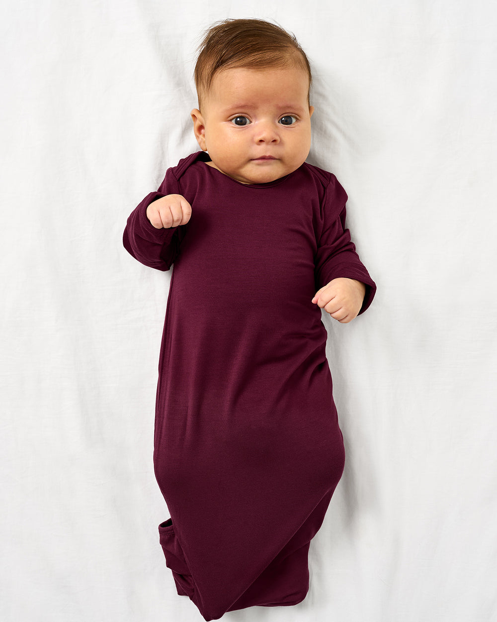 Alternate aerial view of baby wearing the Classic Burgundy Infant Gown